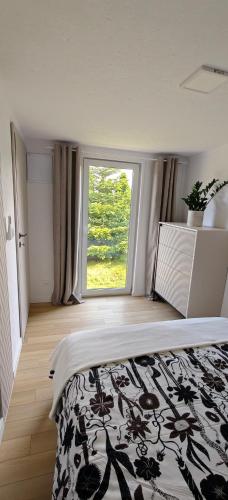 a bedroom with a bed and a large window at Domek na górce u Ani in Polanowo