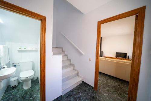 a bathroom with a toilet a sink and a staircase at Casa El Pilar in Serón