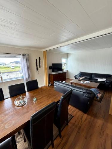 a living room with a table and a couch at ROOMS by Ramberg Beach in Ramberg