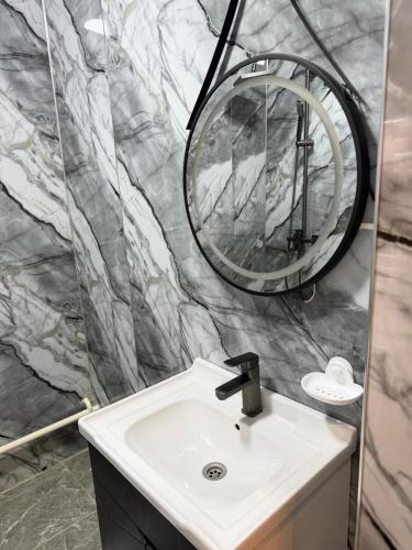 a bathroom with a sink and a mirror at Tunduk Lux House in Teploklyuchinskoye