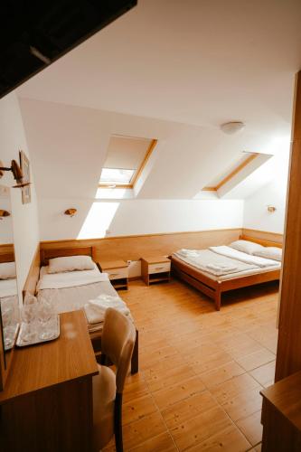 a large room with two beds and a table at Prenočište M & S in Valpovo