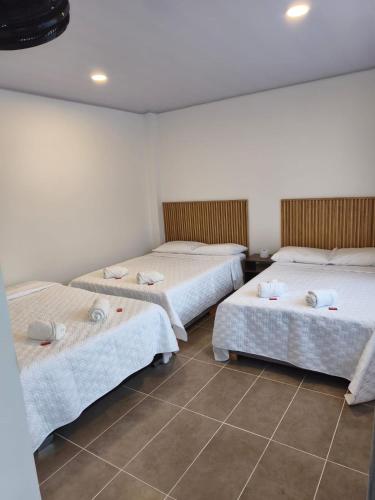 a room with three beds with towels on them at Hotel Boutique 1801 in San Juan de Rioseco 