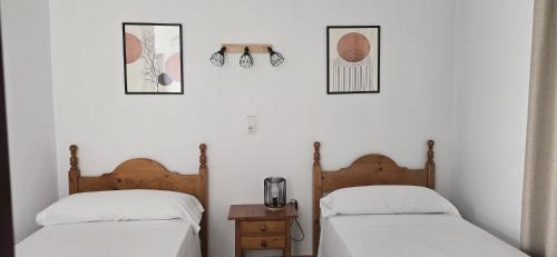 two beds sitting next to each other in a bedroom at Hostal la Campa in Chiclana de la Frontera