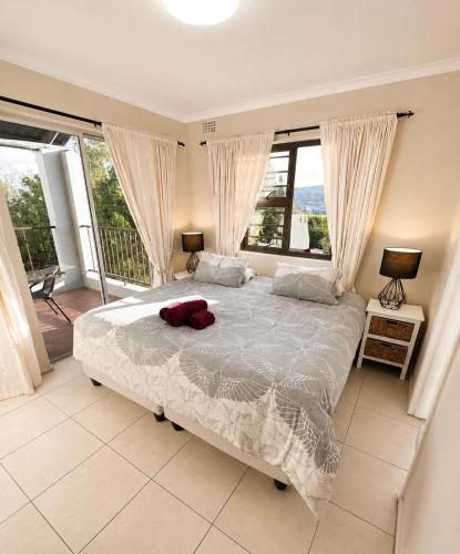 a bedroom with a large bed and large windows at Serengeti Heide Self Catering Flats in Cape Town