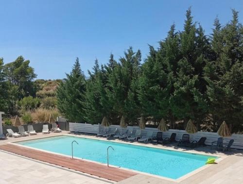 a large swimming pool with chairs and trees at Camping Mas Sud Ardèche in Saint-Just