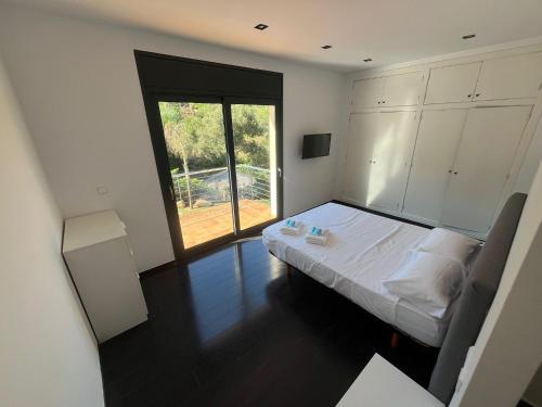 a bedroom with a bed and a large window at Caribe in Platja d'Aro