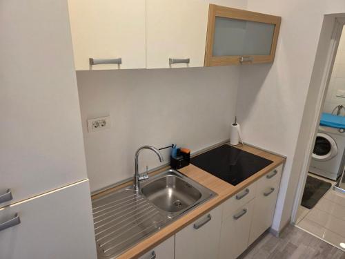 a small kitchen with a sink and a washing machine at apartmani mikek in Domaslovec