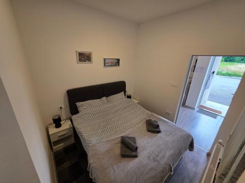 a bedroom with a bed with two shoes on it at apartmani mikek in Domaslovec