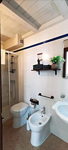 a white bathroom with a sink and a toilet at Casina Raho B&B in Nardò
