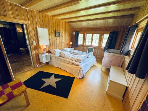 a bedroom with a bed in a wooden room at Atmospheric cabin by Lesjaskogsvatnet in Lesja