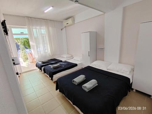 two beds in a room with a window at Avsa BARAN MOTEL apart in Marmara