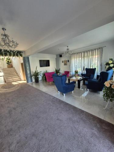 a large living room with blue chairs and a table at Vila Zara in Mamaia Sat/Năvodari