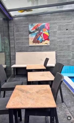 a room with tables and chairs and a painting on the wall at Homelands in Port Harcourt