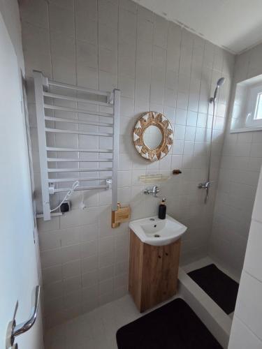 a bathroom with a sink and a shower with a mirror at SALEM apartmany in Radava