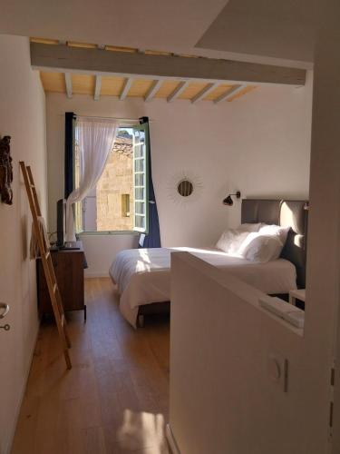 a bedroom with two beds and a window at L'appartement de Sigrid in Pézenas