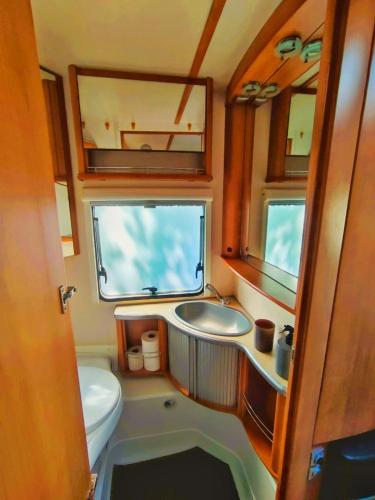 a small bathroom with a sink and a toilet at The Sûre & Simple Caravan in Houschthauser