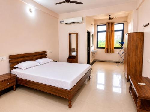 a bedroom with a large bed and a bathroom at Bits Pilani Resort in Bagar