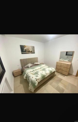 a bedroom with a bed and a painting on the wall at Sweet home in Ariana