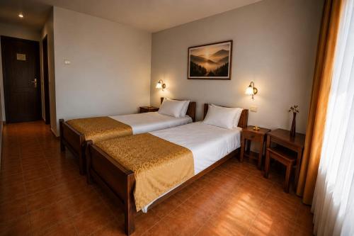 a hotel room with two beds and a picture on the wall at Tortuga in Costinesti
