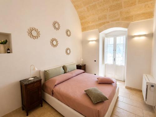 a bedroom with a bed with pink sheets and a window at Dimora IL TULIPANO BIANCO in Massafra