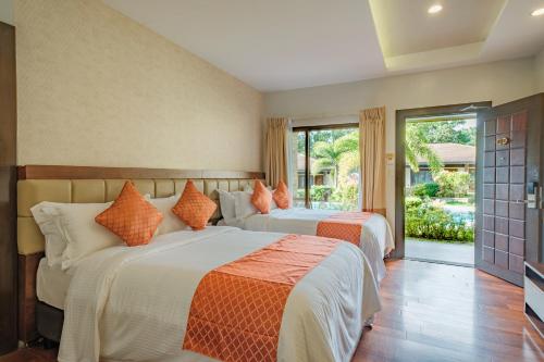 a bedroom with two beds and a large window at Coron Soleil Garden Resort in Coron