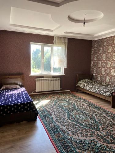 a bedroom with a bed and a large rug at Panorama in Karakol