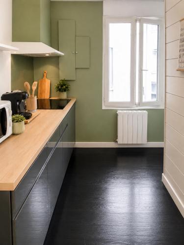 a kitchen with green walls and a counter top at L'Odéon - Hypercentre - Gare SNCF in Nantes