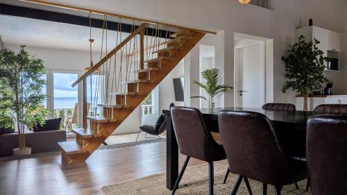 a dining room with a table and a staircase at Villa Capelinhos in Capelo