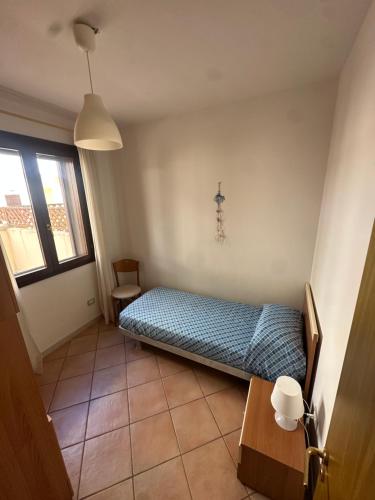 a bedroom with a bed and a table and a window at La CASA DI LUDO in Bernalda