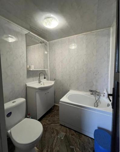a bathroom with a toilet and a tub and a sink at Happy Home in Bucharest