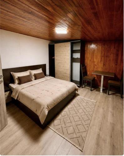 a bedroom with a large bed and a table at Happy Home in Bucharest
