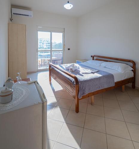 a bedroom with a bed in a room with a window at Serxhio Apartments in Golem
