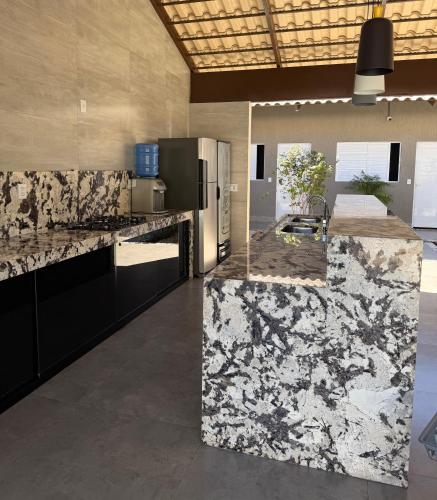a kitchen with black and white marble counter tops at Residência Araguaia in Aruanã