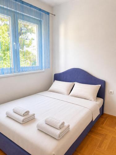 a bedroom with a bed with towels on it at Apartman Centar Agrokop in Trebinje