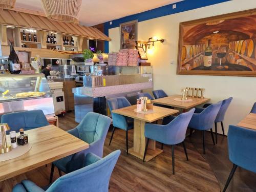 a restaurant with wooden tables and blue chairs at Gästehaus La Puccia in Mittenwald