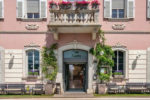 a pink building with a balcony over the door at Hotel Liberty in Levico Terme