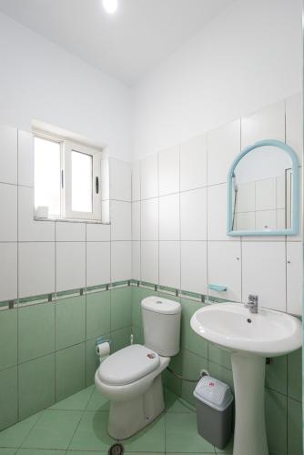 a bathroom with a toilet and a sink at Serxhio Apartments in Golem
