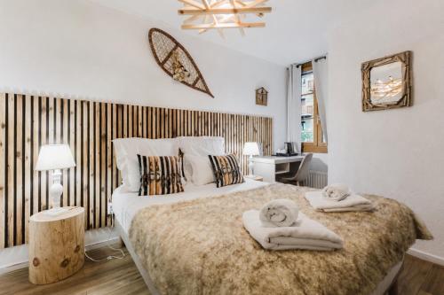 a bedroom with a large bed with towels on it at Hotel Le Blanche Neige in Valberg