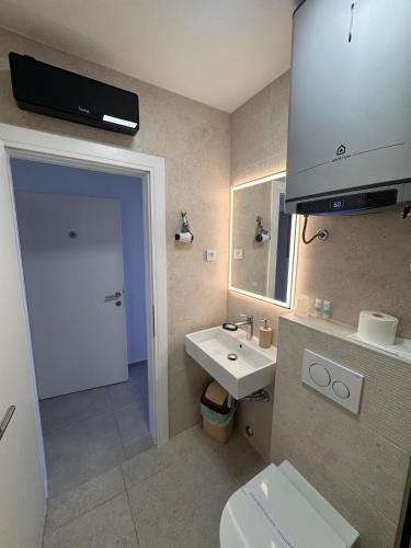 a bathroom with a white toilet and a sink at Berulia accommodation in Brela