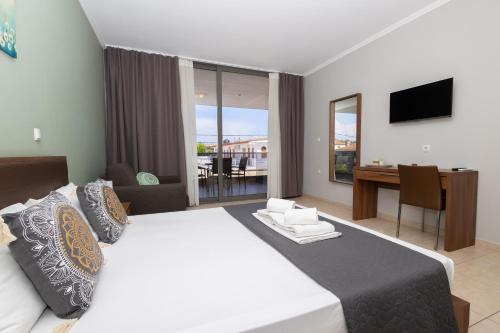 a hotel room with a large bed and a desk at Centrum Rooms in Kallithea Halkidikis