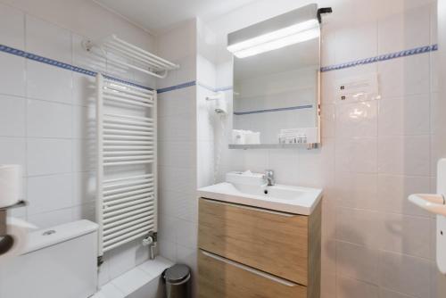 a bathroom with a sink and a mirror at Hotel Le Blanche Neige in Valberg