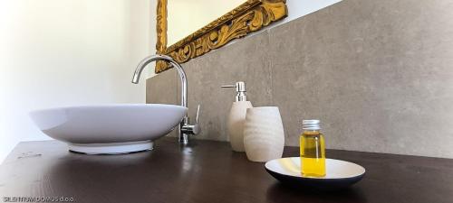 a bathroom with a sink and a bowl on a table at Silentium Domus in Gornje Vreme