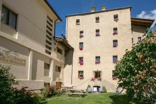 - un grand bâtiment avec une table de pique-nique devant dans l'établissement Résidence Château Royal, à Cogne