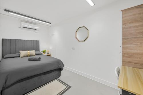 a bedroom with a bed and a mirror on the wall at Cosy Rooms in London