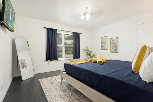 a bedroom with a blue bed and a window at Italian Cottage 2B 1B Duplex KING Pet Friendly in Richardson