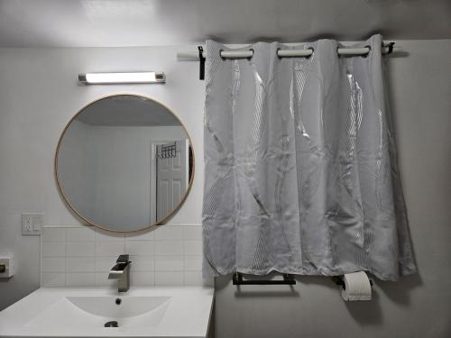 a bathroom with a shower curtain and a mirror at CozyHaven in St. Catharines