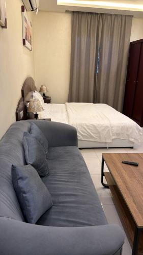 a bedroom with a bed and a table and a couch at غرفه سويت مع مطبخ in Buraydah