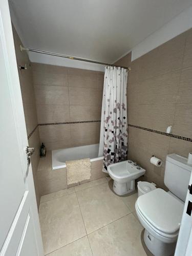 a bathroom with a toilet and a bath tub at Refugio Centro in Puerto Madryn