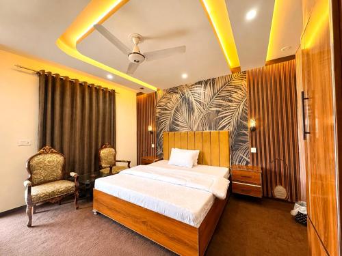 a bedroom with a bed and two chairs in it at The Comfy By Hotel Mountain Track in Taranna