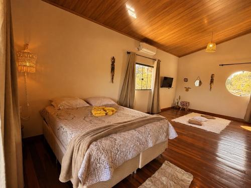 a bedroom with a large bed in a room at Chalé Baru - Ar-cond - Varanda Pôr do Sol - Cavalcante Goiás in Cavalcante